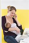 Mother breastfeeding baby,  on the phone