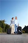 Mature couple with wheelie cases