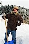L'homme souffrant dos douleur tandis que pelleter de la neige, Hof bei Salzburg, Land de Salzbourg, Autriche