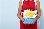 Woman Holding Basket of Corn on the Cob