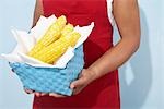 Woman Holding Basket of Corn on the Cob