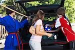 Boys in Karate and Soccer Uniforms Helping Mom Pack the Car