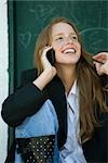 Young woman talking on cell phone, playing with hair