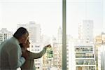 Mature couple looking out view at view of city skyline, woman pointing