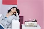 Woman enjoying music, listening to old-fashioned record player