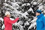 Femme prenant la photo de l'homme avec le téléphone appareil photo à l'extérieur en hiver, Whistler, Colombie-Britannique, Canada