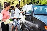 Woman and Teenage Sons Washing Car