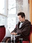 Man in Bathrobe Using Laptop Computer