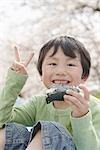 Japanese boy eating sushi and showing v sign