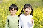 Enfants debout ensemble fleur holding moutarde