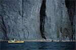 Person Boating on Kayak Near Cliff, Hokkaido, Japan