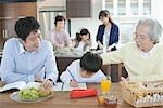 Boy doing homework with his family