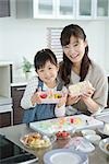 Mother with daughter packing lunch box