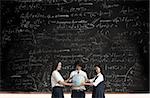Students with globe in front of blackboard