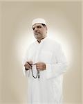 Portrait of a muslim man holding prayer beads