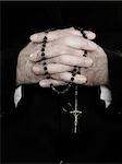 A close up of priest holding prayer beads