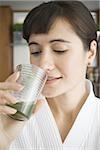 Portrait of a young woman drinking wheatgrass juice