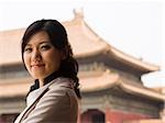 Businesswoman smiling outdoors with pagoda in background