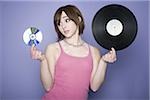 Portrait of a teenage girl holding a record and a CD