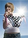 Portrait of a teenage girl drying a bikini bottom on a clothesline