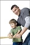 Portrait d'un père enseigne à son fils comment se balancer une batte de baseball