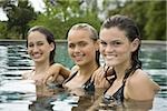 Portrait of three teenage girls smiling in a swimming pool and smiling