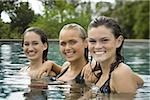 Portrait of three teenage girls smiling in a swimming pool and smiling