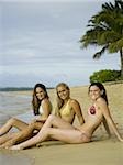 Portrait of three teenage girls sitting on the beach