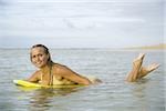 Portrait of a teenage girl floating on a boogie board in the sea