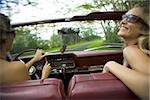 Nahaufnahme von zwei jungen Frauen, die mit Sonnenbrille Autofahren
