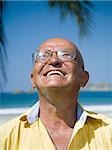 Close-up of a man smiling with his eyes closed on the beach