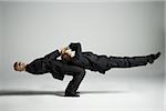 Profile of two male acrobats in business suits performing