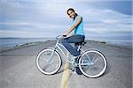 Portrait d'une jeune femme assise sur un vélo