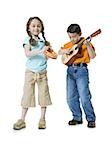 Portrait d'un garçon jouant de la guitare avec une jeune fille debout à côté de lui