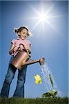 Flachwinkelansicht eines Mädchens eine Pflanze wässern