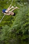 Profile of a boy swinging on a rope