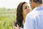 Close-up of a man and a woman holding hands in a field