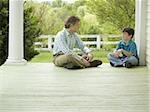 Profil anzeigen: ein Mann und sein Sohn sitzen auf einem Holzfußboden