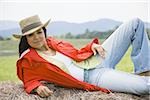 Portrait of a woman lying on a hay bale