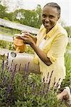 Portrait d'une femme senior arrosant les fleurs