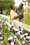 Senior man and a senior woman standing near a fence