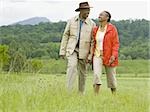 Senior man and a senior woman walking in a field