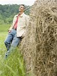 Portrait of a man leaning against a hay bale