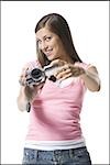Portrait d'une jeune femme tenant un appareil vidéo