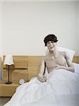 Male mannequin sitting on the bed and laughing
