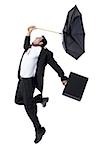 Profile of a businessman holding an umbrella and jumping