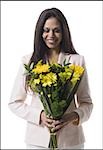 Portrait d'une jeune femme tenant un bouquet de fleurs et souriant