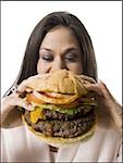 Gros plan d'une jeune femme tenant un hamburger