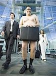 Low angle view of a naked man holding a briefcase