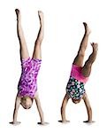 Young female gymnasts doing handstands